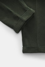 Close-up top view of the cuff and leg detail of 04651/ A trip in a bag Corduroy pants dark green made of soft wide cotton corduroy with seersucker backing.
