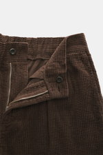 04651/ A trip in a bag Cordhose dunkelbraun aus breitem Baumwoll-Cord mit Seersucker-Innenseite, Reißverschluss, Bundknopf, seitliche Taschen, Nahaufnahme von oben.
