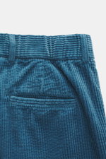 Close-up rear view of 04651/ A trip in a bag Corduroy pants smoky blue, made of soft wide cotton corduroy with seersucker inside, zipper, button, pockets, and fixed hem cuff.