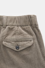 Close-up top view of 04651/ A trip in a bag Corduroy Pants taupe showing soft cotton corduroy fabric, buttoned flap watch pocket, belt loops, and textured seersucker inside for comfort.