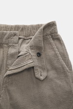 Close-up front view of 04651/ A trip in a bag Corduroy Pants taupe, showing wide cotton corduroy fabric, zipper, button, and waistband with seersucker inside for comfort.
