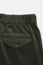 Close-up front view of 04651/ A trip in a bag Corduroy Pants dark green showing soft wide cotton corduroy, buttoned flap watch pocket, and waistband details.