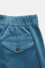 Close-up front view of 04651/ A trip in a bag Corduroy Pants smoky blue showing soft wide cotton corduroy fabric with seersucker inside, waistband, buttoned flap watch pocket, and belt loops, highlighting soft touch, tapered fit, and casual style.