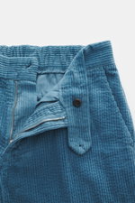 Close-up top view of the partially unzipped waistband and button of 04651/ A trip in a bag Corduroy Pants smoky blue in soft wide cotton corduroy with seersucker inside.