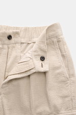 Close-up front view of the partially opened waistband and zipper of 04651/ A trip in a bag Cord Cargo Pants Dark Brown in beige corduroy, showcasing the corduroy made of pure cotton, soft feel, zipper and waistband button, and partially elastic waistband.