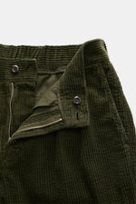 Close-up front detail of 04651/ A trip in a bag Cord Cargo-Jogpants grün with unzipped zipper and button closure, showing soft, slightly elastic corduroy cotton fabric. Modern design, highest comfort: hybrid cargo pants and jogpants from 04651/ A TRIP IN 