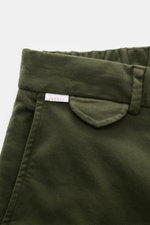 Nahaufnahme der Bund- und Taschenpartie der dunkelgrünen 04651/ A trip in a bag Baumwollhose 'Flex', schmal zulaufend mit teilelastischem Bund.