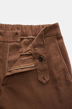 Nahaufnahme der geöffneten Taille der braunen 04651/ A trip in a bag Baumwollhose 'Flex' mit schmal zulaufendem Bund, Reißverschluss, Knopf und französischen Taschen.
