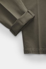 Close-up view of Michael Coal Cotton Pants grey green showing folded ankle cuff, twill made of cotton, soft touch, tapered fit, regular thigh width, ankle length, narrowing, zipper and waistband hook, extended button tab, French pockets, and back pockets 