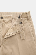 Nahaufnahme der geöffneten Michael Coal Baumwollhose beige von oben, Twill aus Baumwolle, elastisch, weicher Griff, Regular Fit, sehr schmal zulaufend, Reißverschluss, Bundknopf, verlängerter Knopfriegel, französische Taschen, paspelierte Gesäßtaschen.