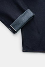 Stone Island Jeans 'Selvedge Indigo Denim - Raw' navy, Detailaufnahme vom Bein mit aufgekrempeltem Saum, Raw Denim, Selvedge-Streifen sichtbar.