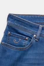Close-up photo of the front pocket area of Jacob Cohen Jeans 'Bard' blau, showing the coin pocket with stitched initial "J," button fly, belt loop, and detailed stitching. Moderner Luxus für jeden Tag: Die Premium-Jeans 'Bard' von JACOB COHEN vereint ikon