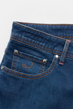 Close-up front view of Jacob Cohen Jeans 'Bard' rauchblau showing slim fit, elastic cotton denim with soft feel, slight used wash, button fly, five-pocket style including coin pocket with initial, stitched back pockets, and leather patch.