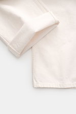 Nahaufnahme der offwhite Ami Paris Jeans 'Large Fit' aus reiner Baumwolle mit griffiger Qualität, geradem Schnitt und umgeschlagenem Bein.