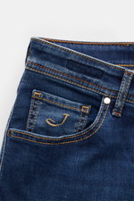 Nahaufnahme der Fronttasche der Jacob Cohen Jeans 'Nick' blau, Denim aus Baumwolle, elastisch, weich, Used-Waschung, Slim Fit, Button Fly, Five-Pocket, Münztasche mit Initial, Gesäßtaschen mit Stitching, Leather Patch in Ponyfell-Optik.