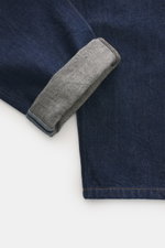 A.P.C. Jeans 'Martin' dunkelblau liegend von oben fotografiert, Detail Umschlag mit dezentem Microfaser-Anteil, Tapered Fit, Five-Pocket-Stil, Zip Fly, kontrastierende Nähte.