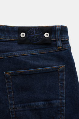 Close-up rear view of Stone Island Jeans 'Stretch Indigo Denim - Rinsed' dark blue showing slim fit denim with compass badge on waistband, cotton, elastic, very tapered.