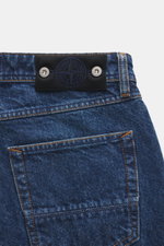 Stone Island Jeans 'Indigo Denim - Medium Grainy Wash' dark blue shown close-up from the back top, featuring pure cotton denim with texture, subtle wash, straight fit, button fly, five-pocket style, and compass badge on waistband. Denim with attitude: The