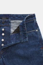 Stone Island Jeans 'Indigo Denim - Medium Grainy Wash' dark blue shown from a top-front close-up, showcasing button fly, five-pocket style, pure cotton denim, material-typical texture, subtle used wash, straight fit and cut, and compass badge on the waist