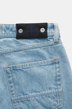 Stone Island Jeans 'Indigo Denim - Light Blue Grainy Wash' light blue shown close-up from the back, featuring black waistband badge, cotton denim, straight cut, and textured wash. Denim with attitude: The jeans 'Indigo Denim - Light Blue Grainy Wash' in S