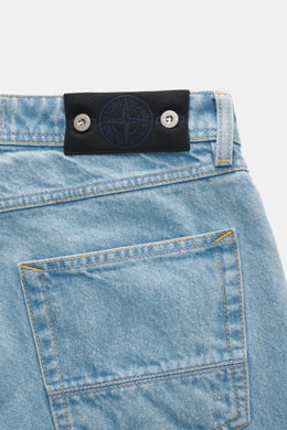 Stone Island Jeans 'Indigo Denim - Light Blue Grainy Wash' light blue shown close-up from the back, featuring black waistband badge, cotton denim, straight cut, and textured wash. Denim with attitude: The jeans 'Indigo Denim - Light Blue Grainy Wash' in S