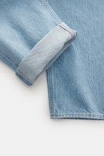 Stone Island Jeans 'Indigo Denim - Light Blue Grainy Wash' light blue shown close-up from above, highlighting folded hem, cotton texture, and subtle wash.