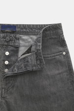 Stone Island Jeans 'Black Denim - Light Grey Wash' grey shown from front close-up with button fly, five-pocket style, and compass badge on waistband. Denim made of pure cotton with typical material texture and subtle used wash in straight fit and straight