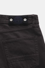 Stone Island Jeans "Indigo Denim - Rinsed" dunkelblau shown from a close-up rear view featuring the waistband with compass badge, button fly, five-pocket style, straight fit, pure cotton denim. Urban classic in modern silhouette, versatile for timeless ci