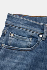 7 for all mankind Jeans 'Slimmy Tapered' rauchblau, Nahaufnahme der Vorderseite mit authentischer Used-Waschung, Baumwoll-Denim, Five-Pocket-Stil, Zip Fly, leicht schmal zulaufend und kleinem Weblabel am Bund.