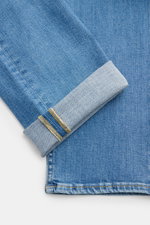 Nahaufnahme der 7 for all mankind Jeans 'Slimmy' blau im Slim Fit, schmal zulaufend, mit authentischer Used-Waschung und umgeschlagenem Saum, fotografiert von oben.
