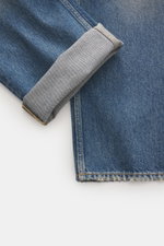 Golden Goose Jeans 'Skate' rauchblau, Detailaufnahme schräg von oben, Denim reine Baumwolle, weicher Griff, Used-Waschung, Distressed, Loose Fit, kurzer Schnitt, Button-Fly, Five-Pocket, Metall-Sterne Patch.