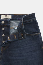 PT Torino Denim Jeans 'Rebel Fit' dunkelblau aus reiner Baumwolle mit leicht griffiger Haptik, Button Fly, Five-Pocket-Stil, Leather Patch, fotografiert aus der Nahaufnahme von oben.