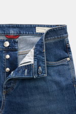 Brunello Cucinelli Jeans 'Traditional Fit' blau, von vorne fotografiert, mit Button Fly, Five-Pocket-Stil, leichter Used-Waschung, elastischem Denim und Logo-Münztasche.