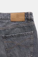 Nahaufnahme der Rückseite der Brunello Cucinelli Jeans 'Leisure Fit' grau mit Veloursleder Patch und Used-Waschung, hochwertiger Denim.