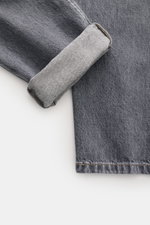 Brunello Cucinelli Jeans 'Leisure Fit' grau, Detailaufnahme aus schräger Perspektive, Denim-Bündchen umgeschlagen, Used-Waschung, reine Baumwolle.