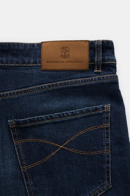 Close-up rear view of Brunello Cucinelli Jeans 'Leisure Fit' grey blue showing velour leather patch, cotton denim with stretch, five-pocket style, and logo stitching.