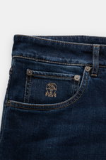 Close-up front view of Brunello Cucinelli Jeans 'Leisure Fit' grey blue showing cotton denim, button fly, five-pocket style, logo-stitched coin pocket, and velour leather patch. Luxurious wearing comfort with slightly stretchy quality, authentic used wash