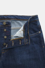 Incotex Jeans dunkelblau aus Baumwolle, leicht elastisch, Five-Pocket-Stil mit Button Fly und Leather Patch, Detailaufnahme von Bund und Knopfleiste.