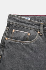 Close-up front view of Ace Denim Jeans 'AD 53' dark grey showing selvedge denim made of cotton, light stretch, soft touch, tapered fit, very slim tapering, button fly, five-pocket style, and embroidered patch.