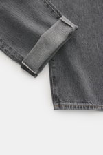 Close-up top-down view of Ace Denim Jeans 'AD 53' dark grey showing selvedge denim made of cotton with light stretch, soft touch, tapered fit, very slim tapering, button fly, five-pocket style, and embroidered patch.