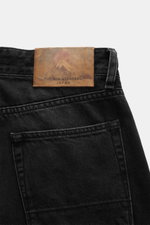 The.Nim Standard Jeans 'Reed' schwarz aus Japan-Denim, Detailaufnahme von hinten oben mit Lederpatch, Five-Pocket, Button Fly, Tapered Fit.