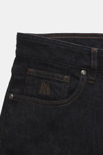 Nahaufnahme der Moorer Jeans 'Milton' dark navy im Five-Pocket-Stil, schräg von oben, Denim aus elastischer Baumwolle, Slim Fit, weicher Griff, Zip Fly, Münztasche mit Sticklogo, Gesäßtaschen mit Stitching, Leather-Patch.