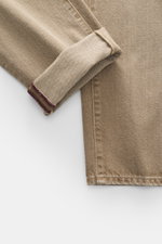 Close-up front view of Barmas Venezia Jeans 'Denver' light brown showing folded cuff, denim made from pure cotton with slightly grippy texture, Regular Fit, tapered, five-pocket style, button fly, and leather patch.