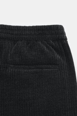 Close-up top view of Emporio Armani Cord jogpants black showing elastic waistband with button, piped welt and back pockets, high-quality microfiber, soft touch, tapered fit.