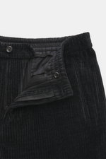 Front close-up view of Emporio Armani Cord jogpants black, featuring high-quality microfiber, soft touch, tapered fit, elastic waistband with button, and piped welt and back pockets.