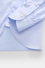 Close-up from above of the Borrelli Business Shirt 'Luciano' Shark Collar light blue cuff and hem, showcasing pure cotton twill, slim fit, French button placket with mother-of-pearl buttons, classic sport cuff, back waist darts, and rounded hemline, highl