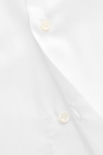 Close-up view of the Borrelli Business Shirt 'Luciano' Shark Collar white, showcasing mother-of-pearl buttons on pure cotton twill fabric with a smooth, light feel, photographed from above to highlight fine craftsmanship and handmade details.