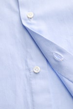 Close-up front view of the Borrelli Business Shirt 'Nando' Shark Collar Light Blue, showcasing fine cotton fabric with a soft, smooth touch, slim fit, French button placket with mother-of-pearl buttons, classic sport cuff, and rounded hemline, highlightin
