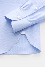 Borrelli Business shirt 'Nando' shark collar light blue/white checked shown from a close-up top-down view, highlighting the soft poplin cotton fabric, fine check pattern, French button placket with mother-of-pearl buttons, classic sport cuff, and rounded 