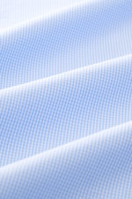 Close-up front view of Borrelli Business shirt 'Nando' shark collar light blue/white checked showcasing fine cotton poplin with smooth feel, check pattern, mother-of-pearl buttons, French button placket, sport cuff, back waist darts, and rounded hem, high